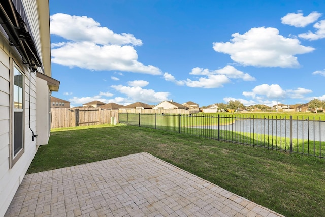 view of yard with a patio area, a fenced backyard, a residential view, and a water view