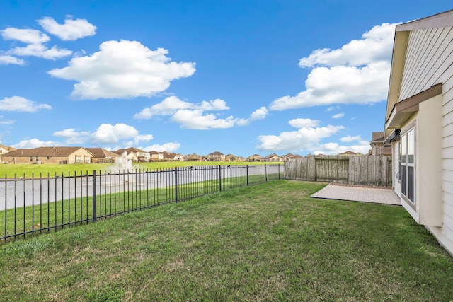 view of yard featuring a fenced backyard and a residential view