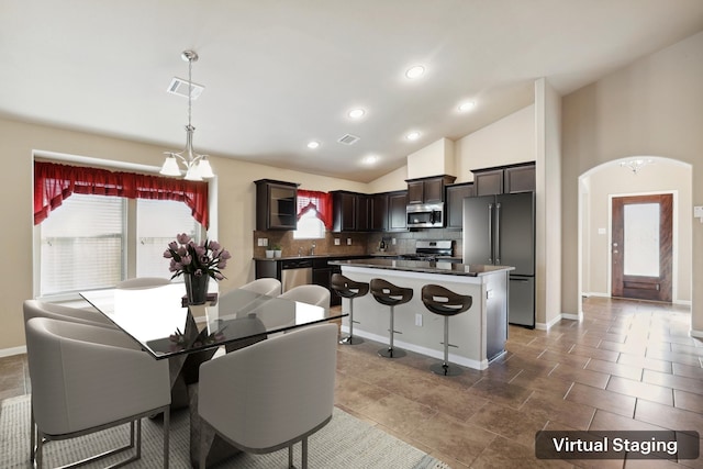 dining room with baseboards, visible vents, arched walkways, lofted ceiling, and a notable chandelier