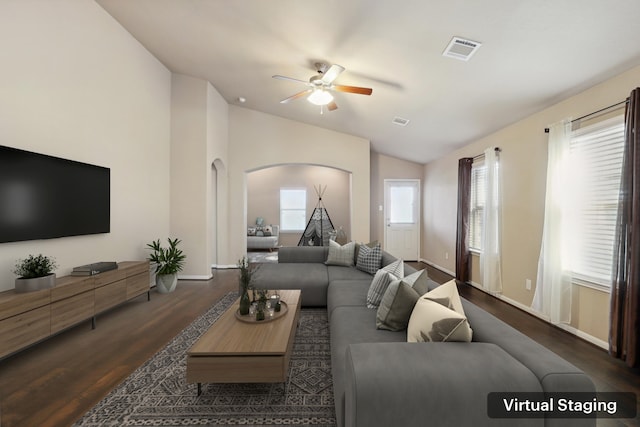 living room featuring lofted ceiling, visible vents, and wood finished floors