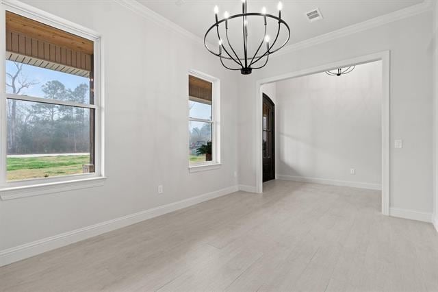 spare room featuring plenty of natural light, wood finished floors, and crown molding