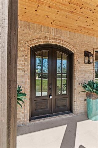 doorway to property featuring brick siding