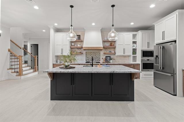 kitchen featuring open shelves, custom exhaust hood, white cabinets, and stainless steel appliances