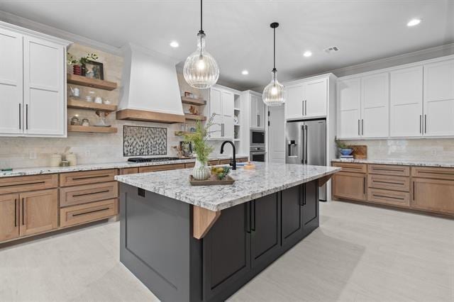 kitchen with stainless steel appliances, white cabinets, custom exhaust hood, and open shelves