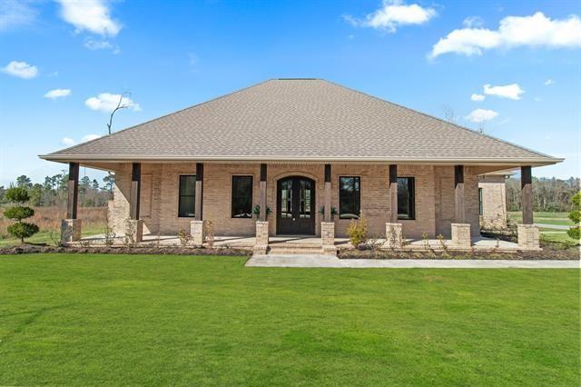 view of front of property featuring a porch, a front lawn, and brick siding