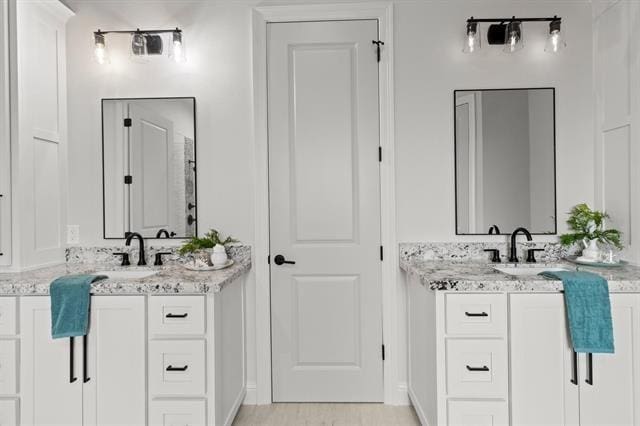 bathroom featuring two vanities and a sink