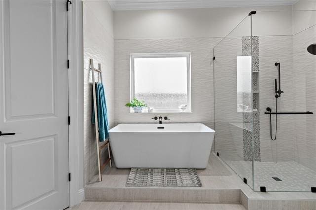 full bathroom with a shower stall, tile walls, and a freestanding bath