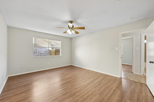 unfurnished room featuring ceiling fan, a textured ceiling, baseboards, and wood finished floors