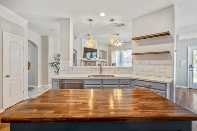 kitchen with gray cabinets, wooden counters, dishwasher, and a sink