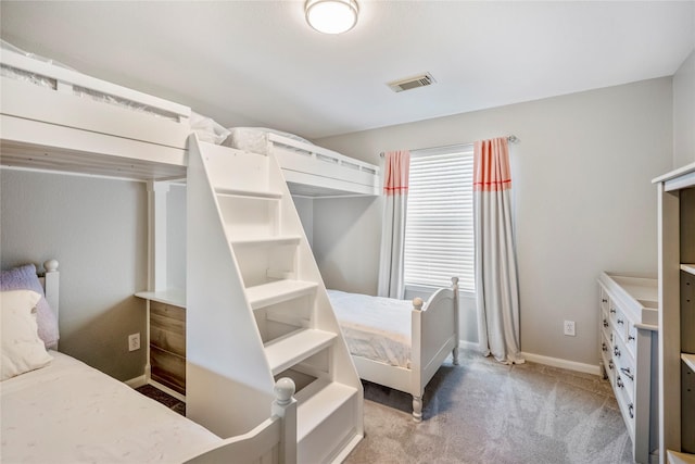 bedroom featuring visible vents, baseboards, and light colored carpet