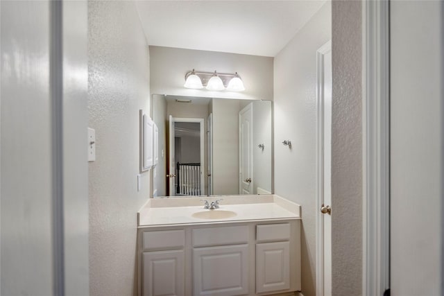 bathroom with vanity and a textured wall