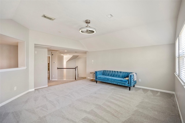 unfurnished room with visible vents, baseboards, carpet, vaulted ceiling, and an upstairs landing