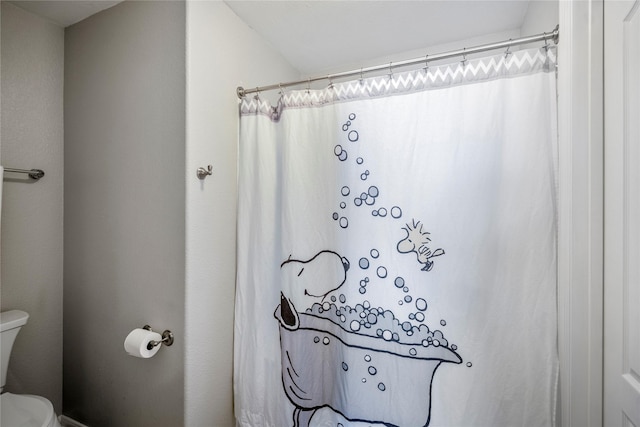 bathroom featuring toilet and a shower with shower curtain