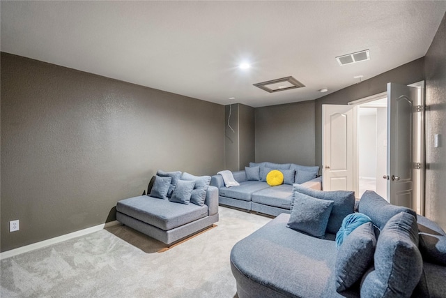 living area with a textured wall, visible vents, baseboards, and carpet floors