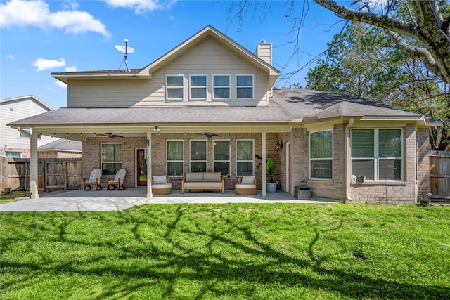 rear view of property featuring brick siding, a ceiling fan, and fence