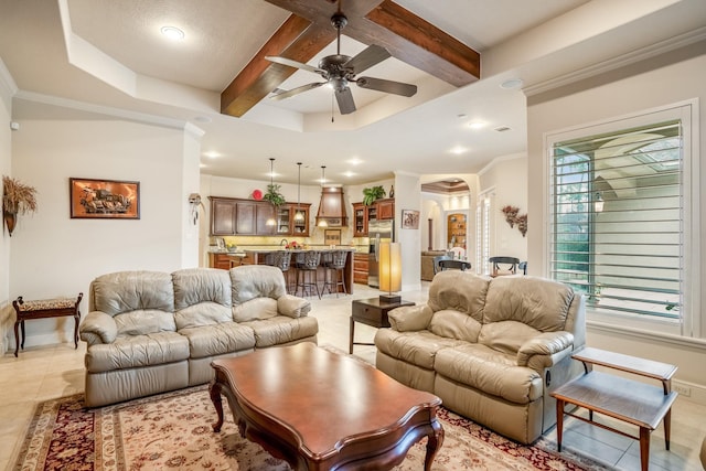 living area featuring light tile patterned floors, ceiling fan, baseboards, and beam ceiling