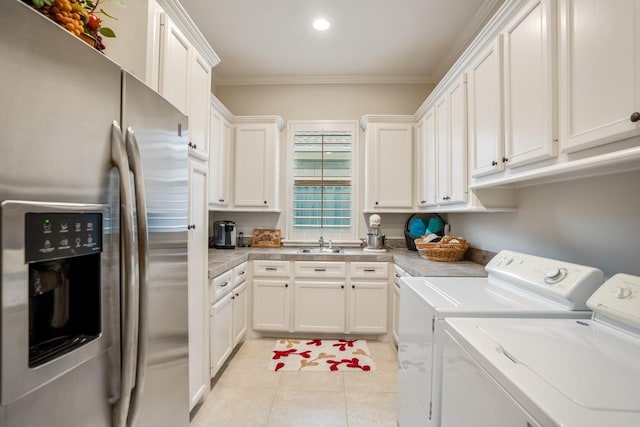 laundry area with light tile patterned floors, washing machine and dryer, a sink, ornamental molding, and cabinet space