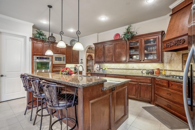 kitchen with arched walkways, light tile patterned floors, a breakfast bar area, stainless steel appliances, and a sink