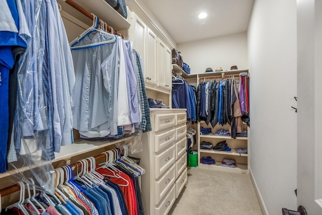 walk in closet with light colored carpet