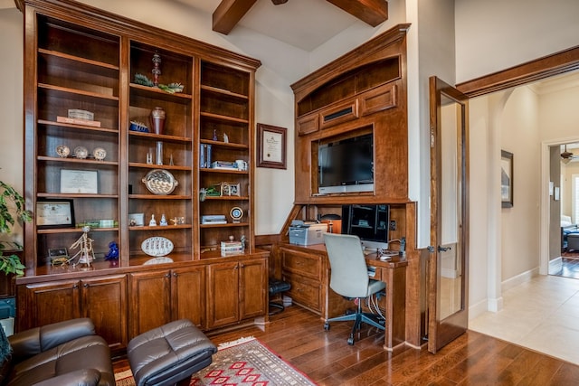 office with dark wood-type flooring, arched walkways, beam ceiling, and baseboards