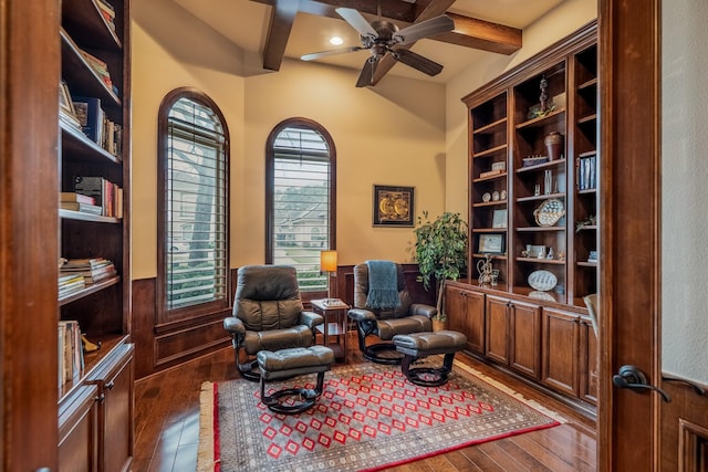 living area featuring dark wood-style floors, ceiling fan, and beamed ceiling