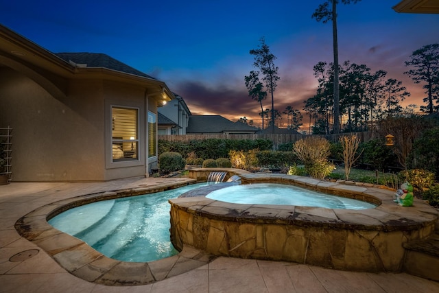 view of pool with fence and an in ground hot tub