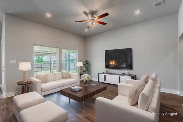 living area with recessed lighting, visible vents, baseboards, and wood finished floors