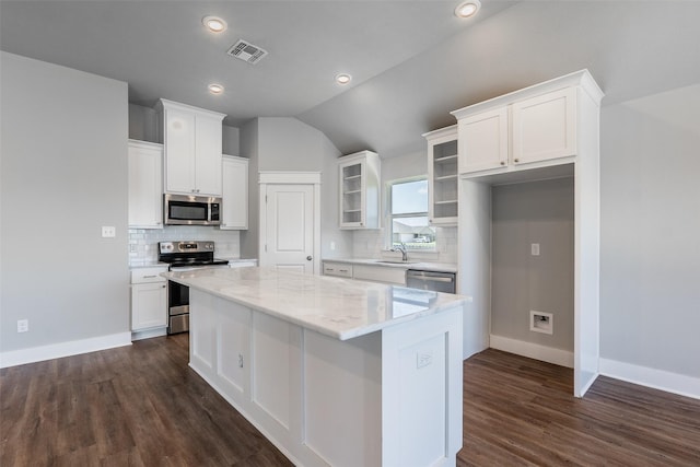 kitchen with visible vents, white cabinets, appliances with stainless steel finishes, a center island, and a sink