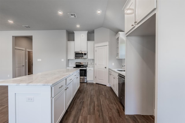 kitchen featuring visible vents, a kitchen island, appliances with stainless steel finishes, and dark wood-style flooring