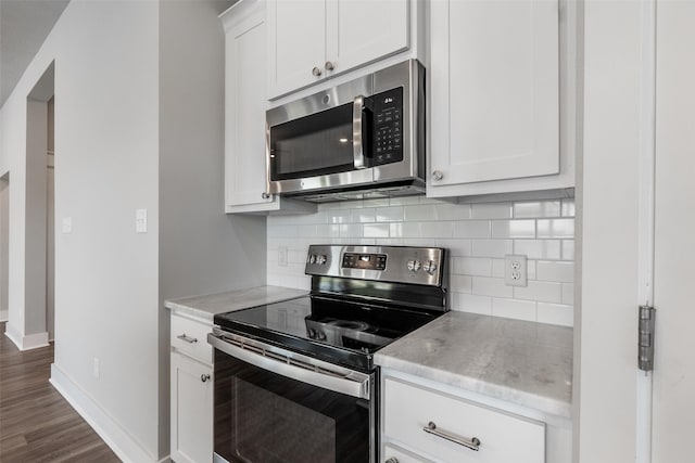 kitchen with white cabinetry, baseboards, appliances with stainless steel finishes, and backsplash