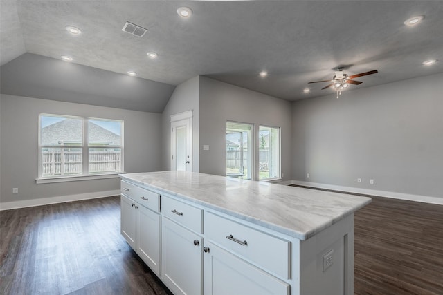 kitchen featuring a center island, dark wood finished floors, visible vents, open floor plan, and white cabinets