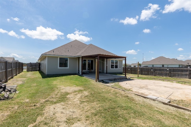 rear view of house with a yard, a fenced backyard, a patio, and a shingled roof