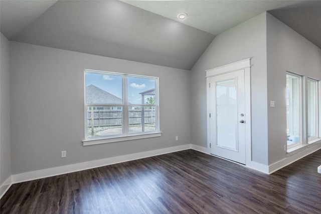 foyer featuring dark wood-style flooring, vaulted ceiling, and baseboards