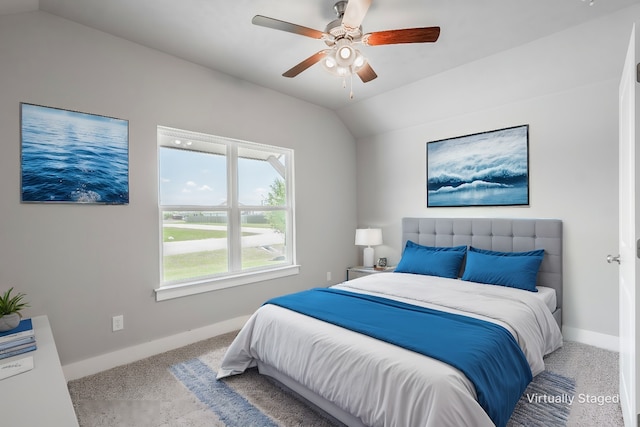 carpeted bedroom featuring a ceiling fan, vaulted ceiling, and baseboards