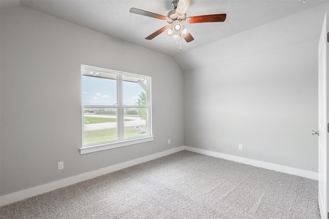 carpeted empty room with vaulted ceiling, baseboards, and ceiling fan