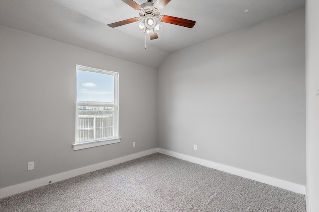 empty room with vaulted ceiling, carpet, a ceiling fan, and baseboards