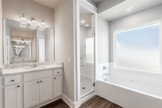 full bathroom with a bath, a shower stall, wood finished floors, and vanity