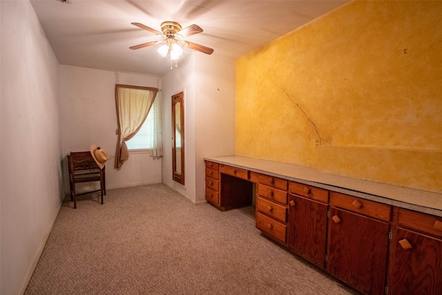 office space with light carpet, baseboards, a ceiling fan, and built in study area