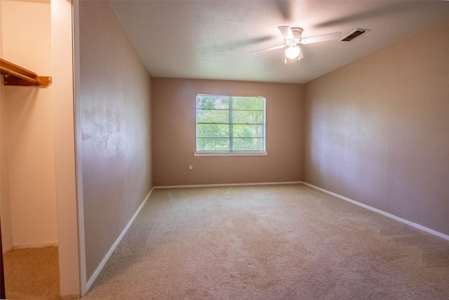 unfurnished room with ceiling fan, baseboards, visible vents, and light colored carpet