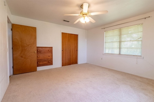 unfurnished bedroom with a closet, visible vents, ceiling fan, and carpet flooring