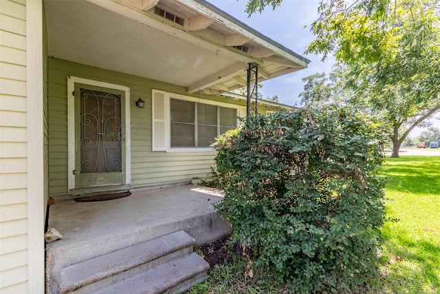 doorway to property with a lawn