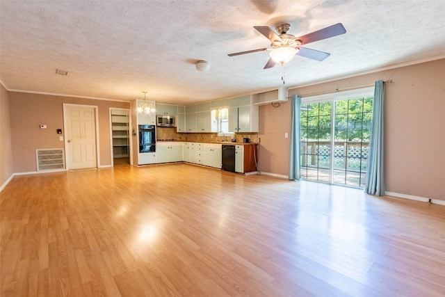 unfurnished living room with light wood finished floors, visible vents, and a textured ceiling