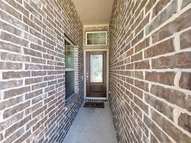 view of exterior entry featuring brick siding