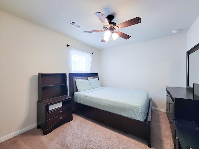 bedroom with a ceiling fan, light colored carpet, visible vents, and baseboards