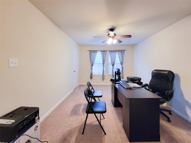 office space with light carpet, a ceiling fan, and baseboards