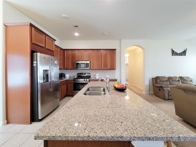 kitchen with arched walkways, visible vents, appliances with stainless steel finishes, open floor plan, and a sink