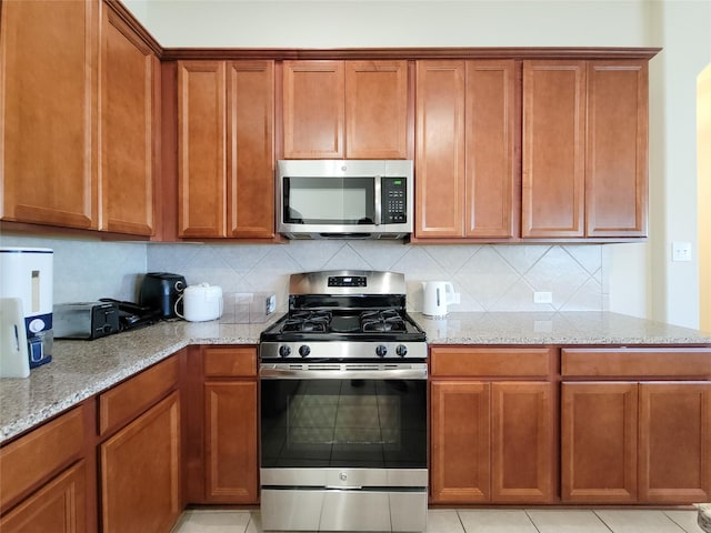 kitchen featuring appliances with stainless steel finishes and light stone countertops