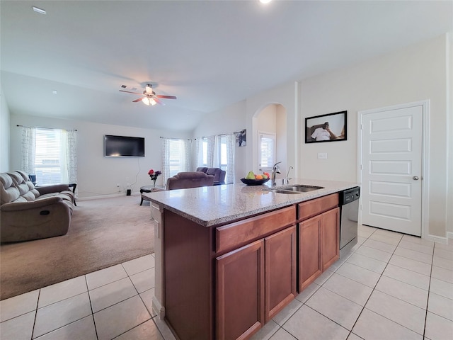 kitchen featuring light tile patterned floors, stainless steel dishwasher, open floor plan, light carpet, and a sink