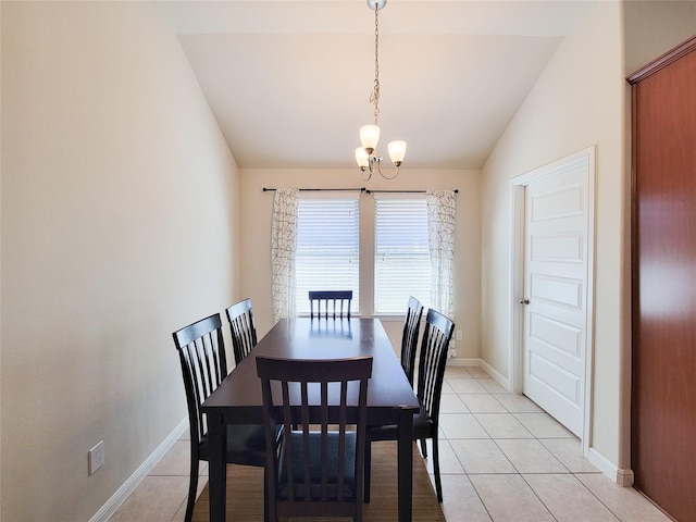 dining space with vaulted ceiling, light tile patterned flooring, a notable chandelier, and baseboards