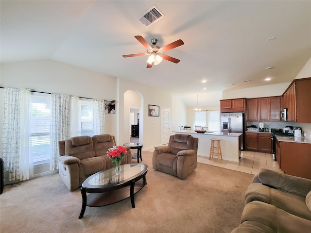 living area featuring arched walkways, visible vents, light carpet, and light tile patterned flooring